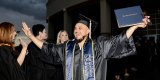 West Hills College Lemoore's Aaron Estrada gives high fives to faculty members following Thursday's graduation ceremony in the Golden Eagle Arena.